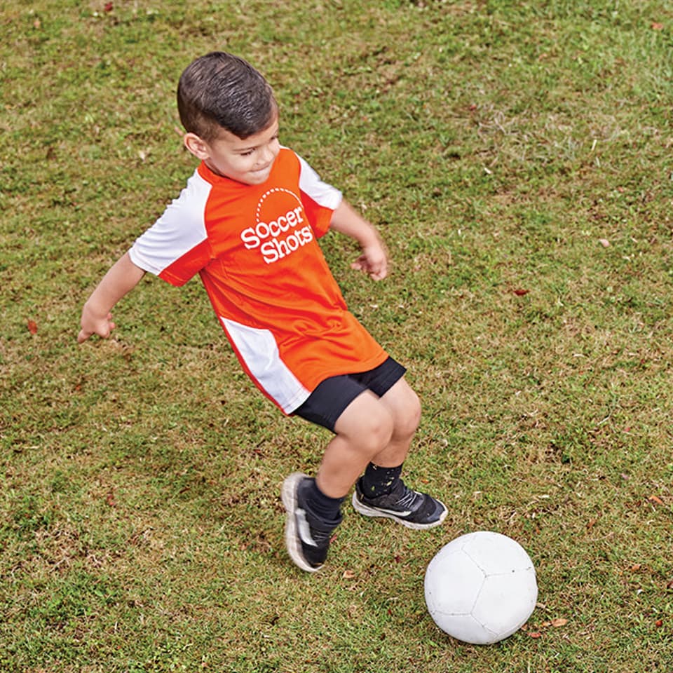 A child kicking a soccer ball