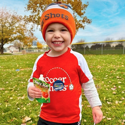 A child holding a Tree Top apple sauce pouch