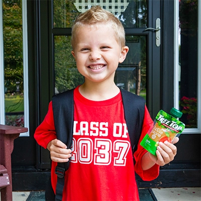 A Child holding a Tree Top apple sauce pouch