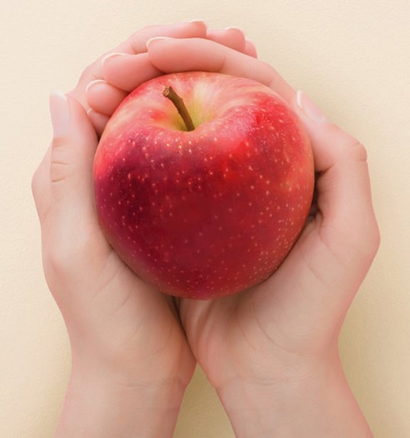 Hands holding an apple